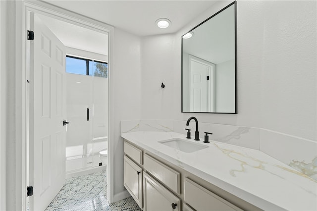 bathroom featuring a shower stall, vanity, and toilet