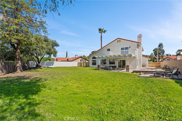 rear view of house with a fire pit, a lawn, a chimney, a fenced backyard, and a patio