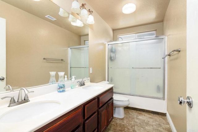 full bathroom featuring combined bath / shower with glass door, a sink, visible vents, and double vanity