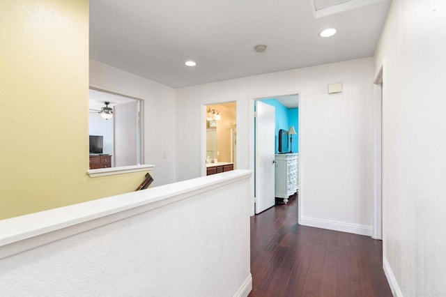 hallway with baseboards, dark wood-style flooring, an upstairs landing, and recessed lighting