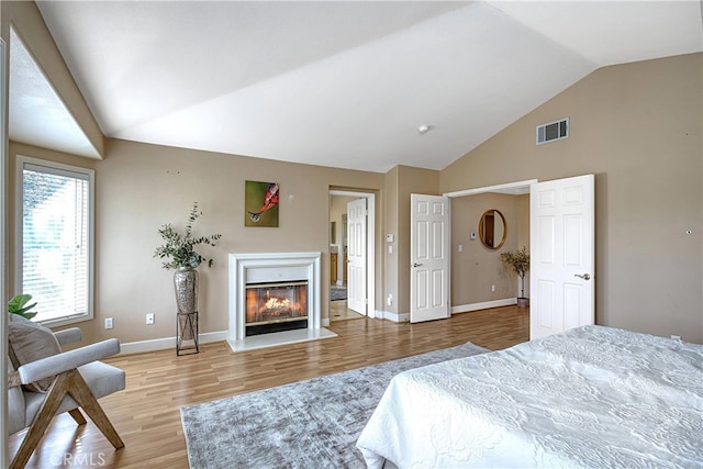 24932 Normans Way, Calabasas, CA 91302 - bedroom featuring light wood finished floors, a glass covered fireplace, and high vaulted ceiling