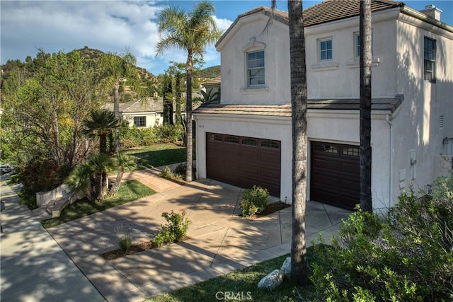 24932 Normans Way, Calabasas, CA 91302 - view of front of house featuring an attached garage, stucco siding, driveway, and a tile roof