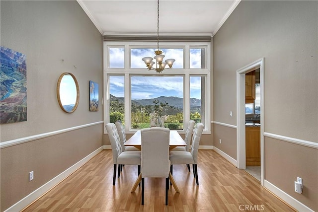 24932 Normans Way, Calabasas, CA 91302 - dining area featuring ornamental molding, a chandelier, light wood-style flooring, and a mountain view