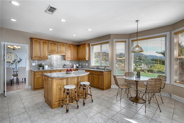 24932 Normans Way, Calabasas, CA 91302 - kitchen with healthy amount of natural light, a center island, decorative backsplash, light stone counters, and recessed lighting