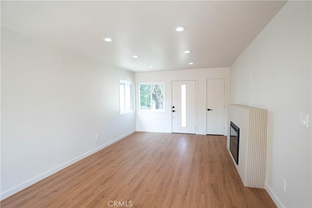 5808 Adele Ave, Whittier, CA 90606 - unfurnished living room with a glass covered fireplace, recessed lighting, and light wood-style floors
