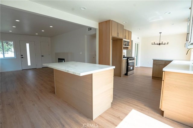 5808 Adele Ave, Whittier, CA 90606 - kitchen featuring a notable chandelier, light wood-style floors, appliances with stainless steel finishes, a sink, and light brown cabinetry