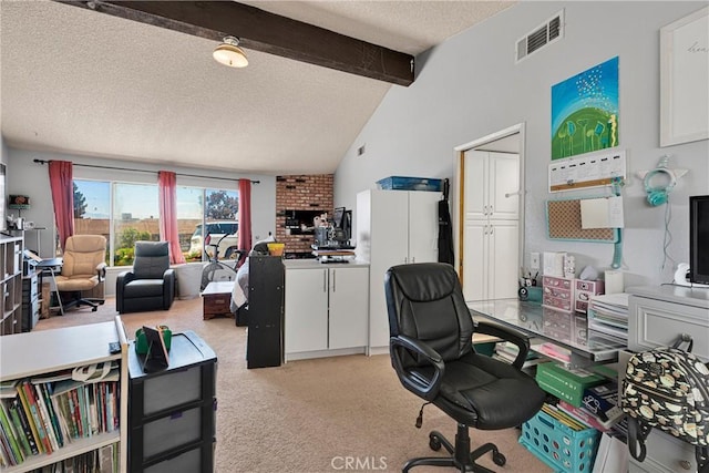 office featuring light colored carpet, a textured ceiling, visible vents, and lofted ceiling with beams