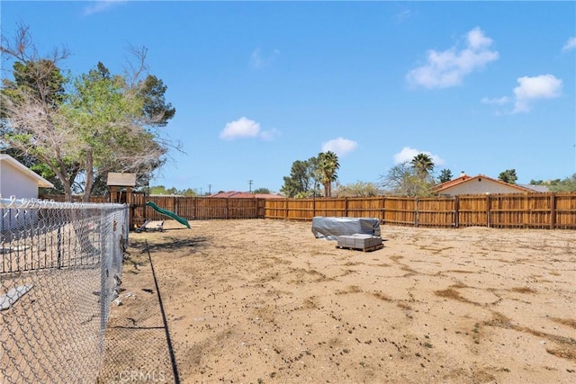 view of yard featuring a fenced backyard and a playground