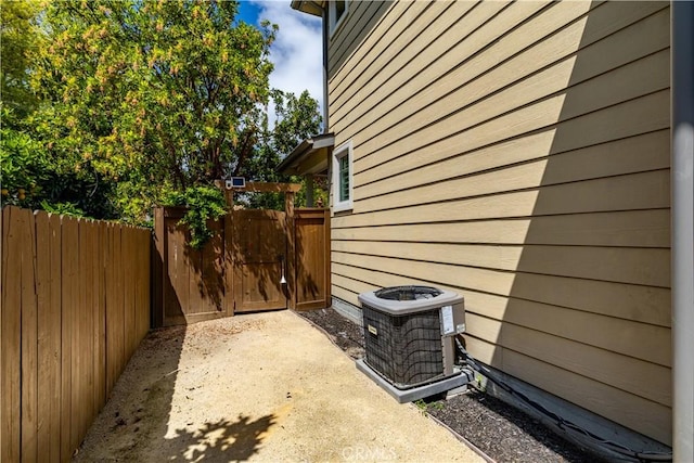 view of home's exterior with central AC, a gate, and fence