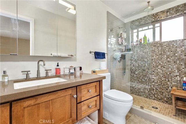 bathroom featuring tiled shower, toilet, and vanity