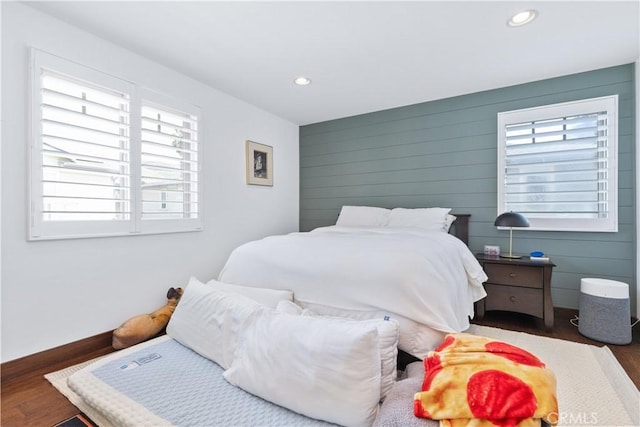 bedroom featuring wooden walls, recessed lighting, wood finished floors, and baseboards
