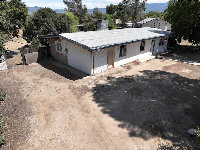 view of front facade featuring fence, cooling unit, and a mountain view