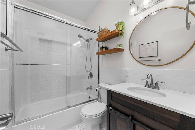 full bath featuring tile walls, toilet, enclosed tub / shower combo, vanity, and tile patterned floors