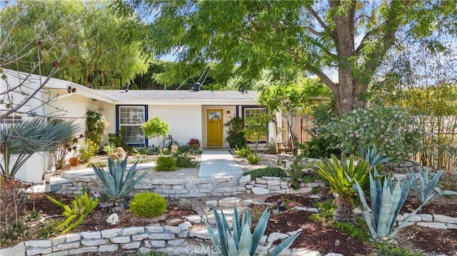 view of front of property with stucco siding and fence