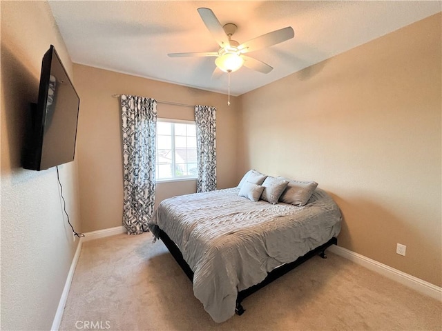 bedroom with baseboards, a ceiling fan, and light colored carpet