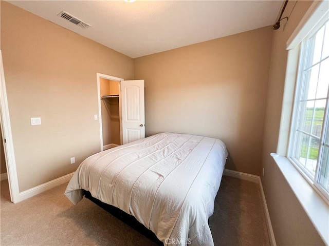 carpeted bedroom featuring baseboards and visible vents