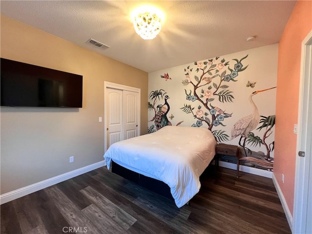 bedroom with visible vents, baseboards, a closet, and dark wood finished floors