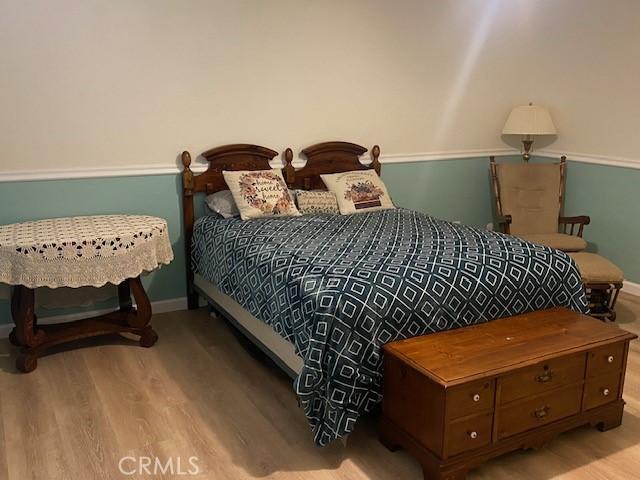 bedroom featuring wood finished floors and baseboards