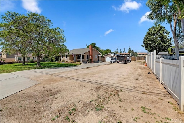 22432 Van Buren St, Grand Terrace, CA 92313 - view of front of home with concrete driveway, a residential view, a front lawn, and fence