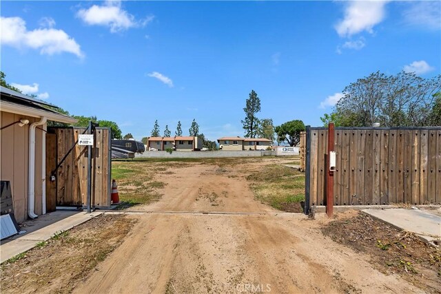 22432 Van Buren St, Grand Terrace, CA 92313 - view of street featuring a gate, a gated entry, and dirt driveway