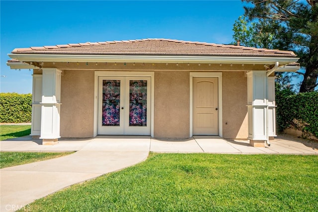 doorway to property featuring stucco siding and a lawn