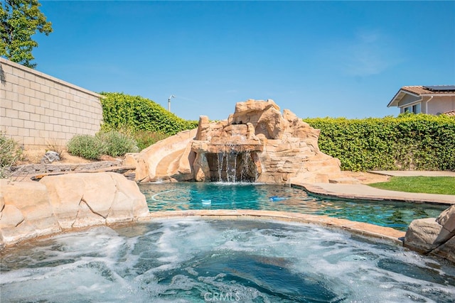 view of swimming pool with an in ground hot tub