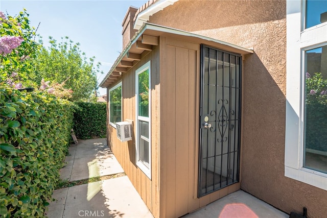 exterior space featuring a patio area, cooling unit, and stucco siding