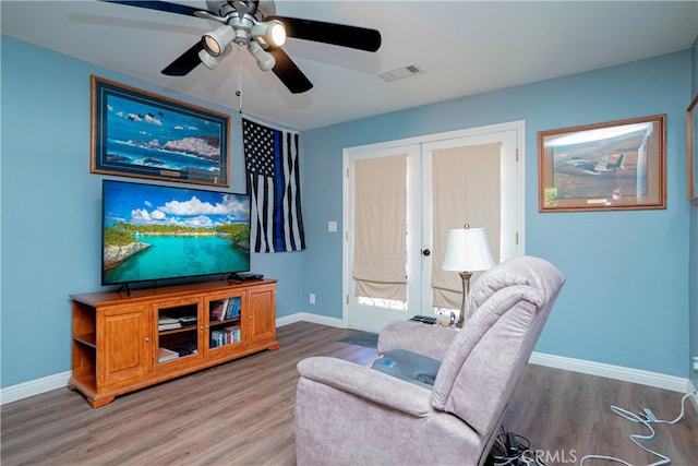 living room with french doors, baseboards, and wood finished floors