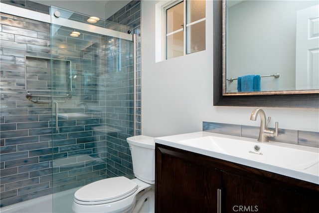full bath featuring a tile shower, toilet, and vanity