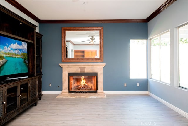 unfurnished living room featuring wood finished floors, baseboards, crown molding, and ceiling fan
