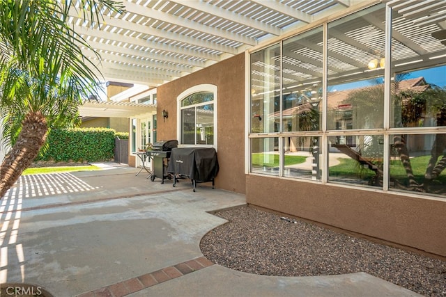 view of patio with area for grilling and a pergola