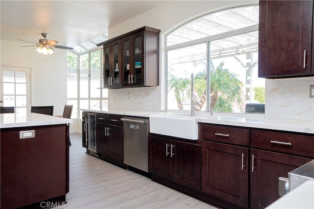 kitchen with tasteful backsplash, light wood-style flooring, light countertops, ceiling fan, and stainless steel dishwasher