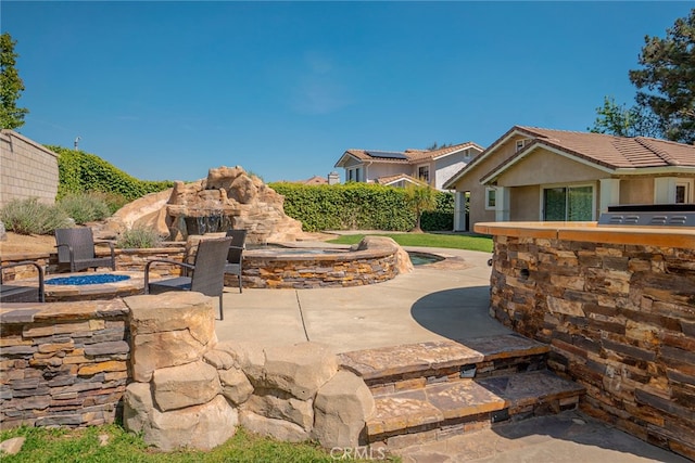 view of patio / terrace with an outdoor fire pit and fence