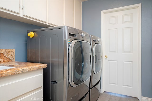 laundry area with separate washer and dryer and cabinet space