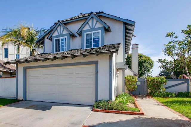 view of front facade with stucco siding, fence, an attached garage, and concrete driveway