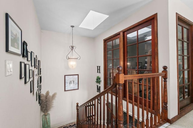 stairs featuring a skylight and baseboards