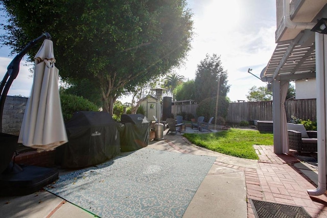 view of patio / terrace featuring a shed, an outdoor structure, a fenced backyard, and grilling area