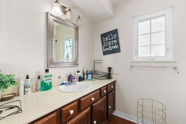 bathroom featuring vanity, wood finished floors, and baseboards