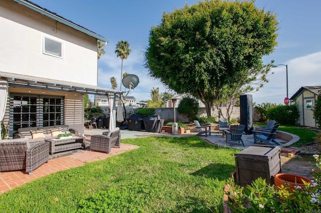 view of yard featuring an outdoor living space with a fire pit and a patio area