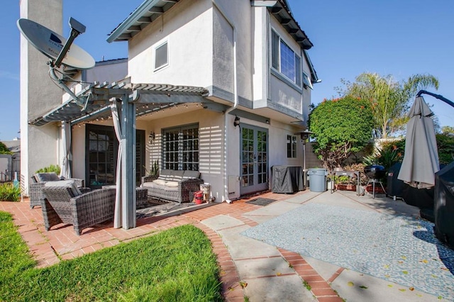 rear view of property with stucco siding, a pergola, outdoor lounge area, and a patio area
