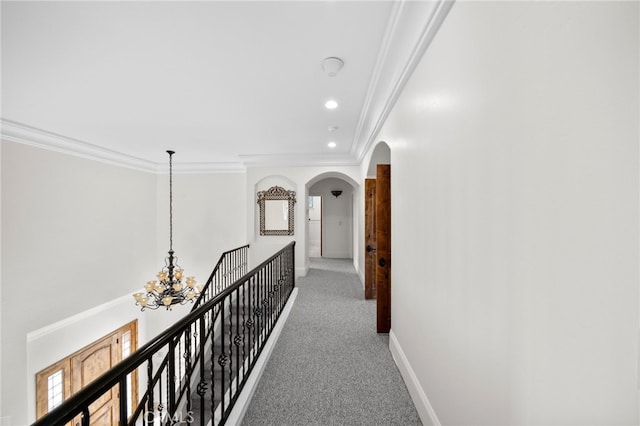 hallway with recessed lighting, a chandelier, crown molding, light carpet, and arched walkways