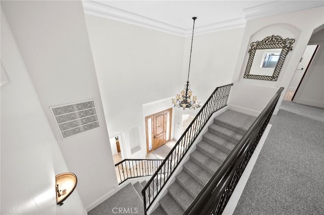 stairs featuring carpet flooring, visible vents, baseboards, an inviting chandelier, and ornamental molding