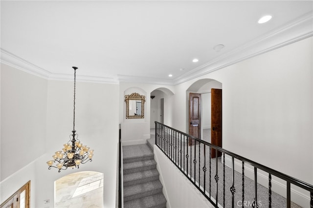 hallway featuring crown molding, recessed lighting, arched walkways, and an inviting chandelier