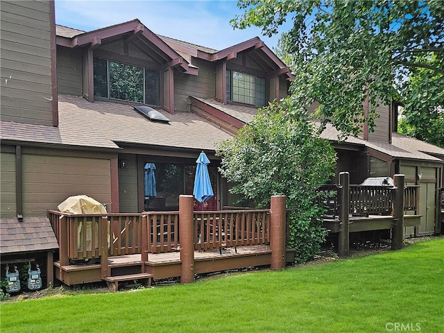 755 Cienega Rd Unit B, Big Bear Lake, CA 92315 - rear view of house with a shingled roof, a deck, an attached garage, and a lawn