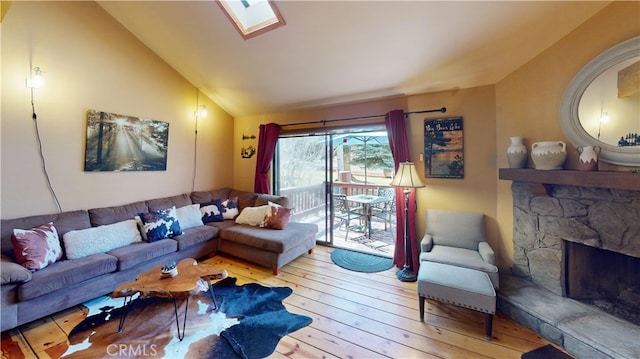 755 Cienega Rd Unit B, Big Bear Lake, CA 92315 - living area with vaulted ceiling with skylight, a stone fireplace, and hardwood / wood-style flooring