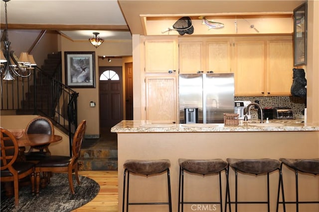 755 Cienega Rd Unit B, Big Bear Lake, CA 92315 - kitchen with stainless steel fridge, an inviting chandelier, a peninsula, and light brown cabinets