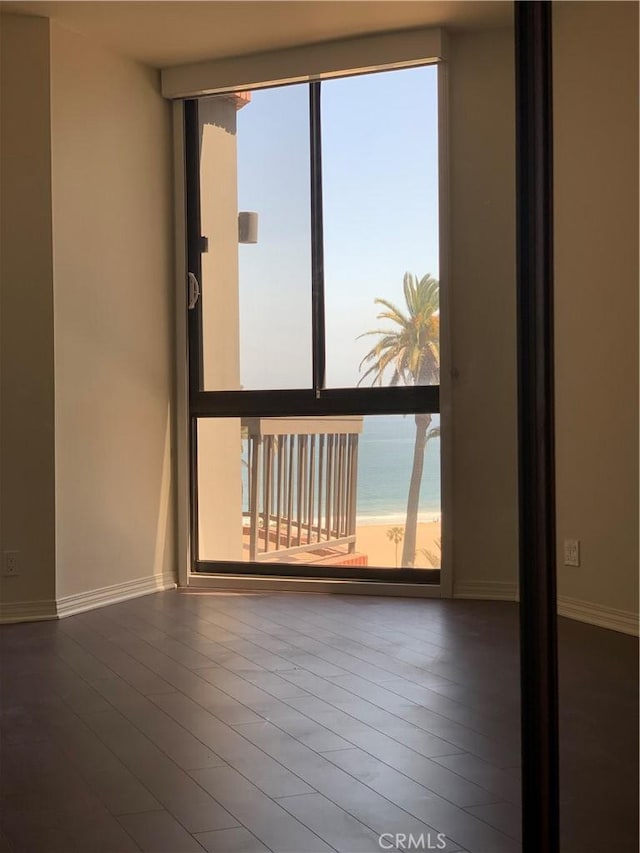 unfurnished room with wood finished floors and baseboards