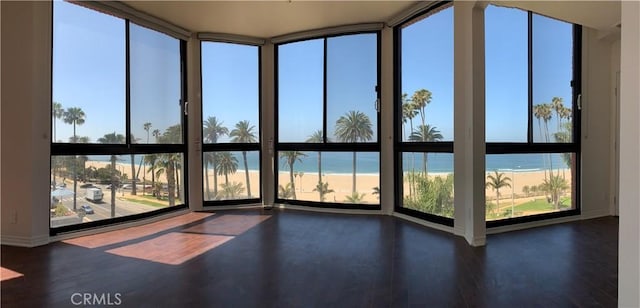 unfurnished sunroom with wood finished floors and a water view