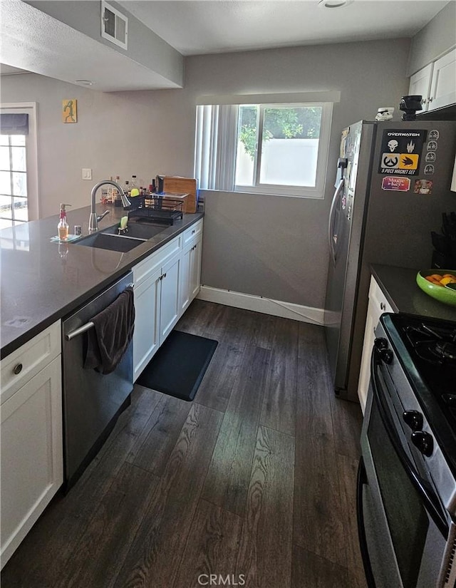 kitchen with stainless steel appliances, visible vents, a wealth of natural light, and dark wood-style floors