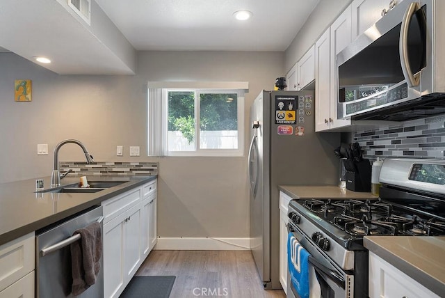 1192 Mitchell Ave Unit 66, Tustin, CA 92780 - kitchen featuring stainless steel appliances, a sink, white cabinets, light wood-style flooring, and recessed lighting
